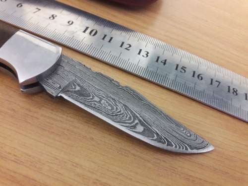 Handmade Damascus steel folding knife with Wooden handle scales.