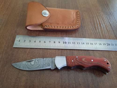 Handmade Damascus steel folding knife with MICARTA handle scales.