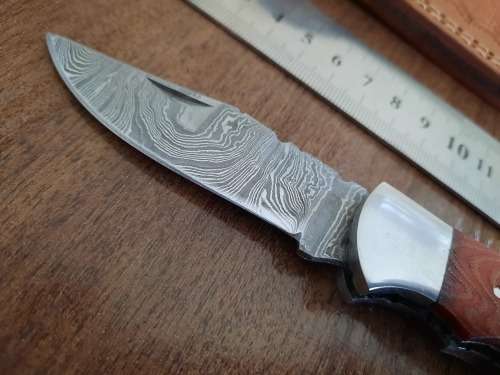 Handmade Damascus steel folding knife with MICARTA handle scales.
