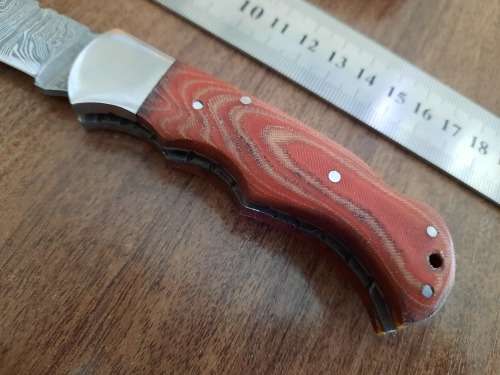 Handmade Damascus steel folding knife with MICARTA handle scales.