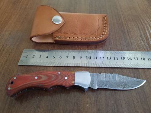 Handmade Damascus steel folding knife with MICARTA handle scales.
