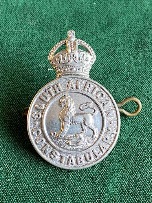 SA CONSTABULARY,WHITE METAL HELMET AND CAP BADGE-SOLID CENTRE-2 LUGS-MEASURES 43X39M