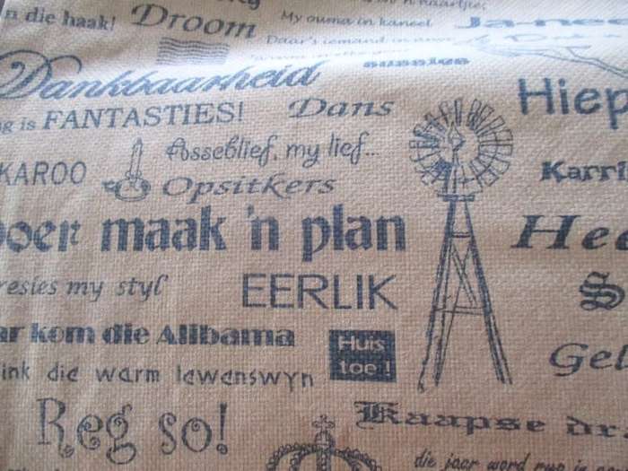 A very large, very long, wide table runner with South African scenes, songs and sayings