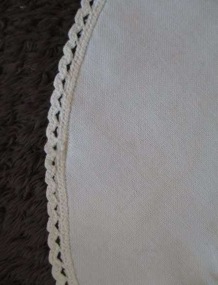 A larger round vintage neatly hand embroidered with sweet peas and hand crocheted border