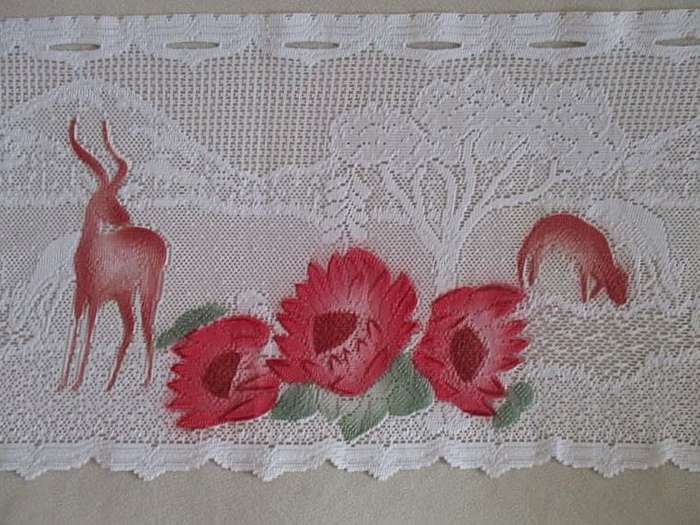An unusual `half mast` lace curtain with with coloured proteas and animals
