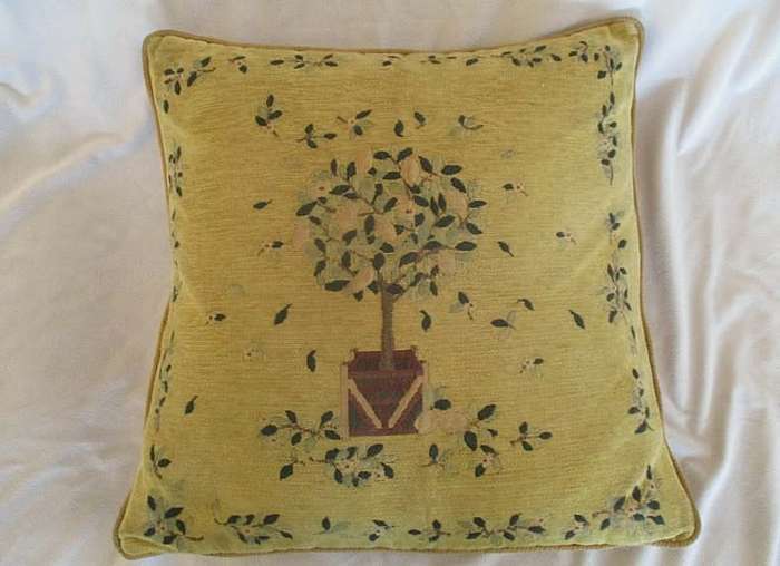 A vintage tapestry-style cushion with potted tree design