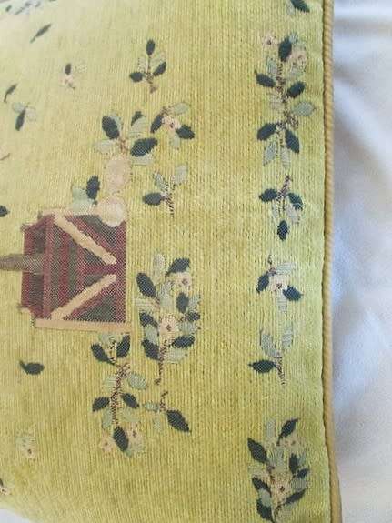 A vintage tapestry-style cushion with potted tree design