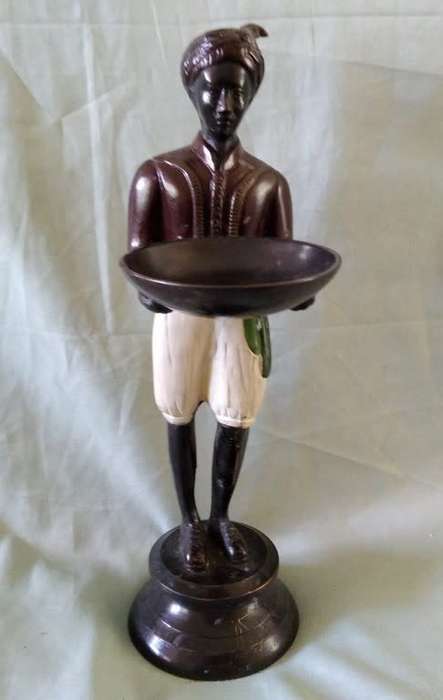 Decorative metal statuette of man holding a bowl