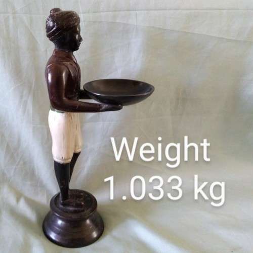 Decorative metal statuette of man holding a bowl