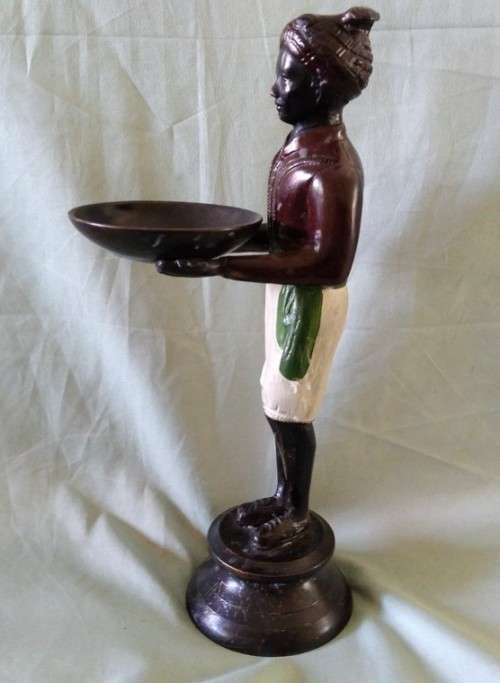 Decorative metal statuette of man holding a bowl