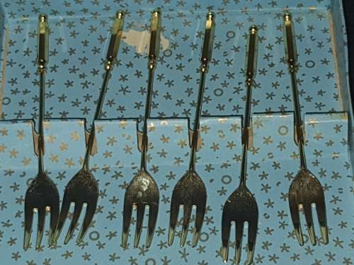 A COMPLETE SET GOLD PLATED COCKTAIL FORKS SOLD AS IS