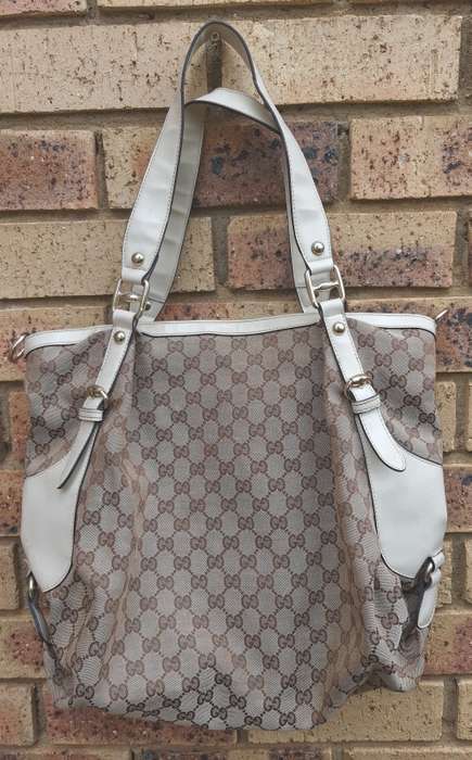 A TAN GUCCI HANDBAG IN GOOD CONDITION SOLD AS IS
