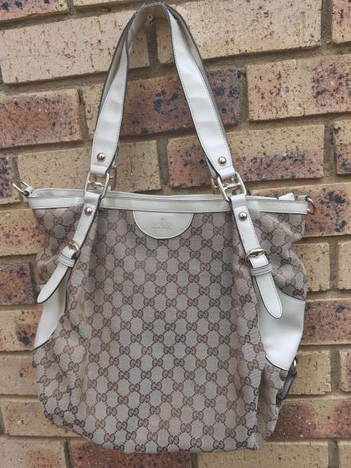 A TAN GUCCI HANDBAG IN GOOD CONDITION SOLD AS IS