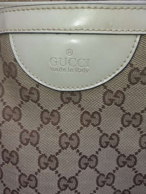 A TAN GUCCI HANDBAG IN GOOD CONDITION SOLD AS IS
