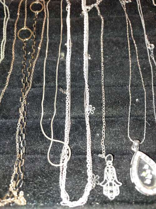 A COLLECTION OF SILVER PLATED AND STAINLESS STEEL NECKLACES WITH PENDANTS SOLD AS IS