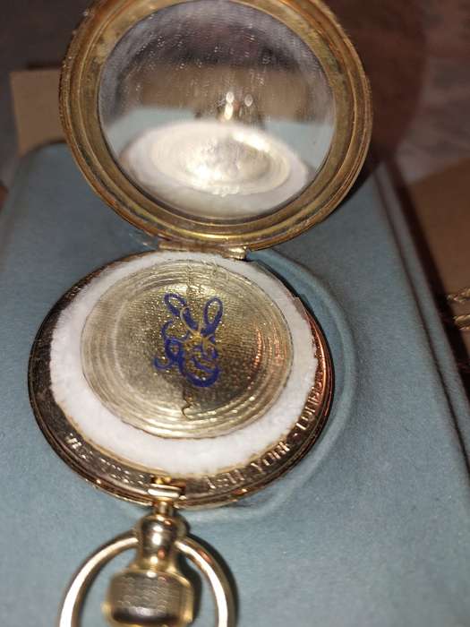 AN ANTIQUE ESTEE LAUDER FILIGREE WATCH STYLE COMPACT GOLD PLATED  WITH CHAIN