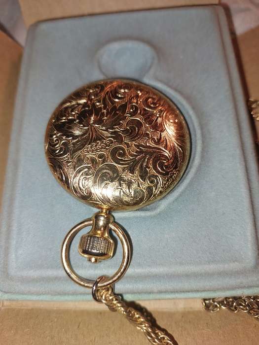 AN ANTIQUE ESTEE LAUDER FILIGREE WATCH STYLE COMPACT GOLD PLATED  WITH CHAIN