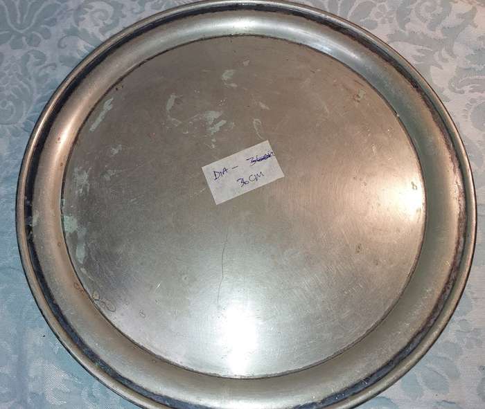 A ROUND CATERERS TRAY SILVER PLATED NEEDS TO BE POLISHED AND SOLD AS IS