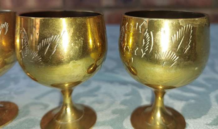 A VINTAGE SET OF FIVE BRASS GOBLETS