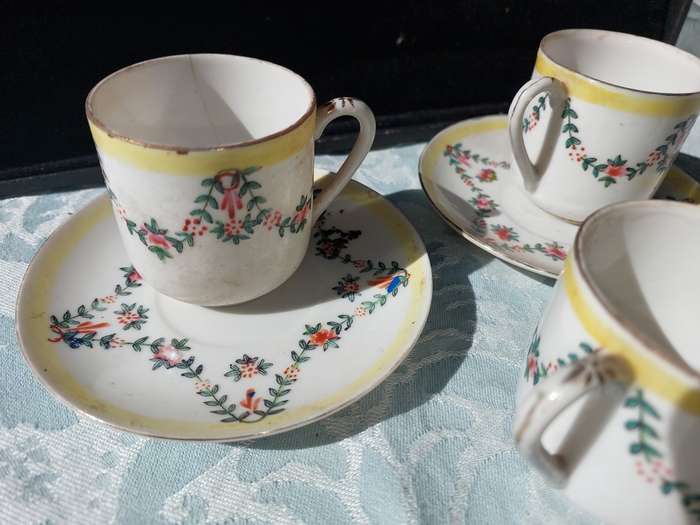 A COLLECTION OF HAND PAINTED TEA CUPS AND SAUCERS