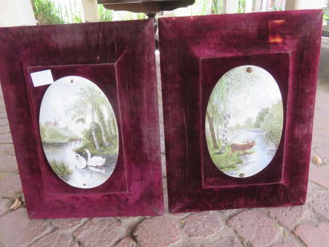 Pair of hand painted and signed porcelain oval plaques, mounted on felt frames