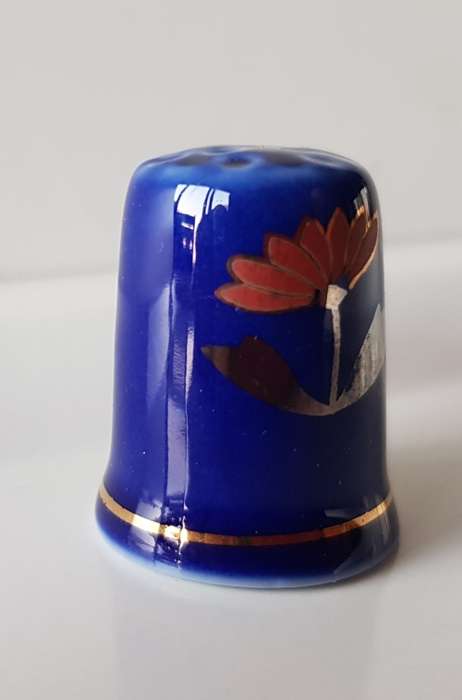 A Vintage collectors thimble. Thimble in blue glaze, painted flower in front