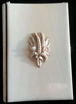 ANTIQUE  IVORY CASED NOTEBOOK AND PENCIL,  FRONT COVER DECORATED WITH WHEAT AND FIELD FLOWERS
