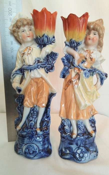 Vintage porcelain couple carrying vases
