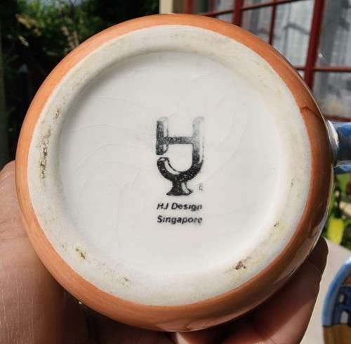 A HANDPAINTED HJ DESIGNS SINGAPORE COFFEE CUP AND SAUCER