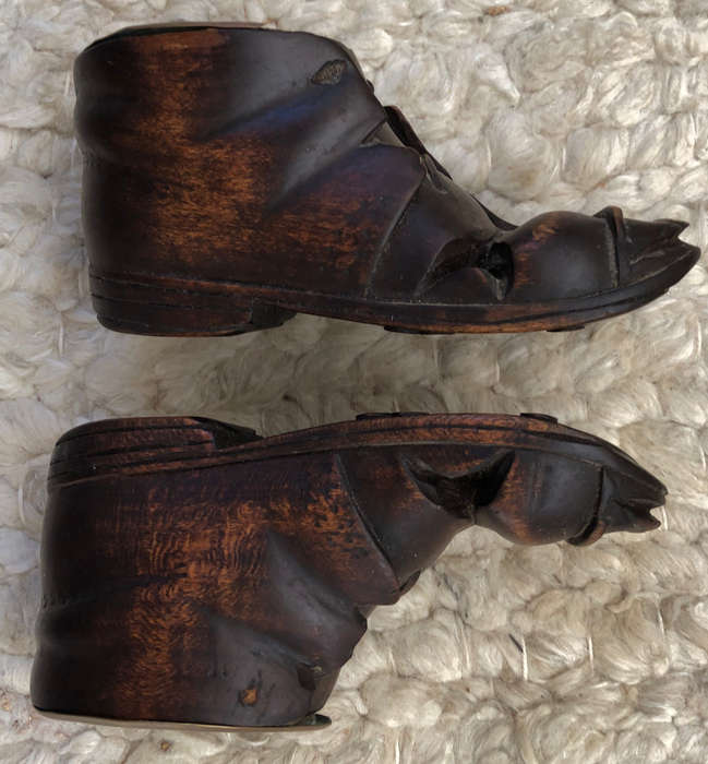 CARVED ANTIQUE PAIR OF WOODEN BOOTS WITH BRASS INSERT