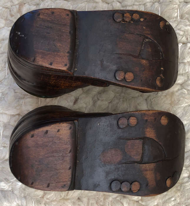 CARVED ANTIQUE PAIR OF WOODEN BOOTS WITH BRASS INSERT