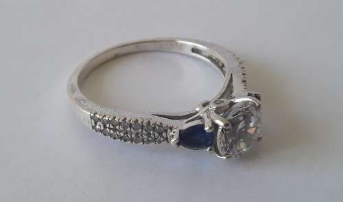 Solid sterling silver trilogy ring with clear centre stone and blue side stones. Size: N (17mm)