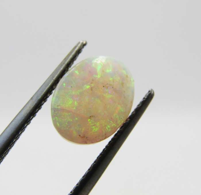 Beautiful orange & green flashes Opal of 1,21 carat - Oval Cabochon white opal