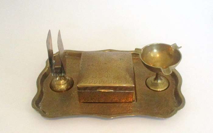 A BRASS CIGAR BOX ON A TRAY WITH MATCHBOX HOLDER AND ASHTRAY