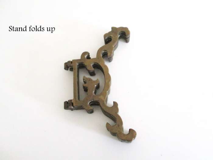 A VINTAGE BRASS PLATE EMBOSSED WITH FRUIT AND ETCHED CENTER ON A STAND