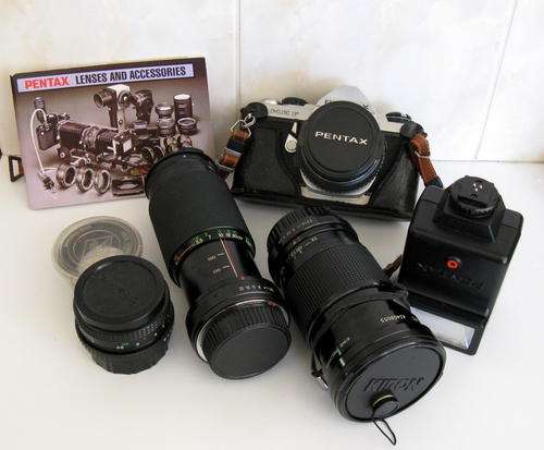 A PENTAX CAMERA AND VARIOUS LENSES AND INSTRUCTION BOOKLET--Along with items not on main photo