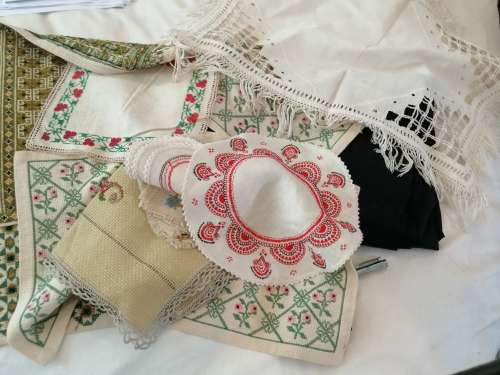 A SELECTION OF ANTIQUE TABLEWARE SOME OF WHICH ARE EMBROIDERED