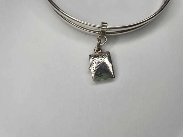Trio of sterling silver bangles with a locket