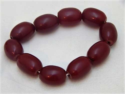 A RED AFRICAN AMBER BEADED BRACELET WITH 10 BEADS