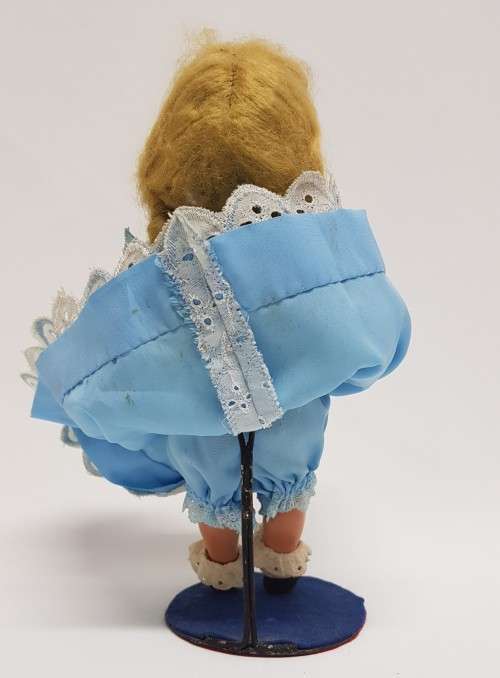 Vintage Hard Plastic Doll 26cm dressed in hand stitched dress on metal stand as per photo