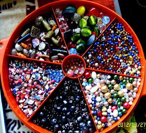 CONTAINER FULL OF BEADS, LOTS AND LOTS OF THEM.
