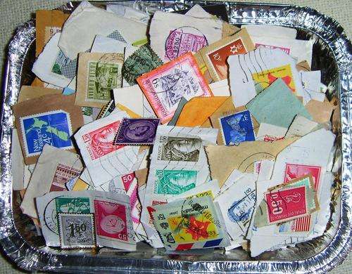Worldwide stamps on paper in tin tub.