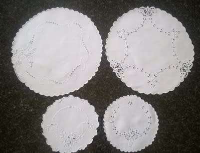 Four white linen embroidered doilies