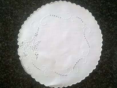 Four white linen embroidered doilies