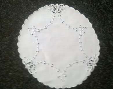 Four white linen embroidered doilies