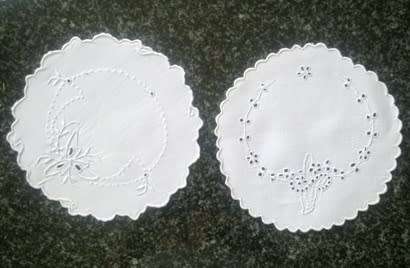 Four white linen embroidered doilies
