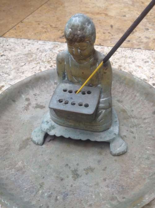 vintage brass buddha incense burner on brass plate