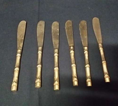 SIX BRASS BUTTER KNIVES