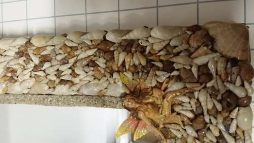 A HEAVY  MIRROR  FRAMED WITH SEA SHELLS AND FAIRIES / COLLECTION ONLY )