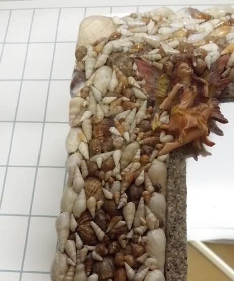 A HEAVY  MIRROR  FRAMED WITH SEA SHELLS AND FAIRIES / COLLECTION ONLY )